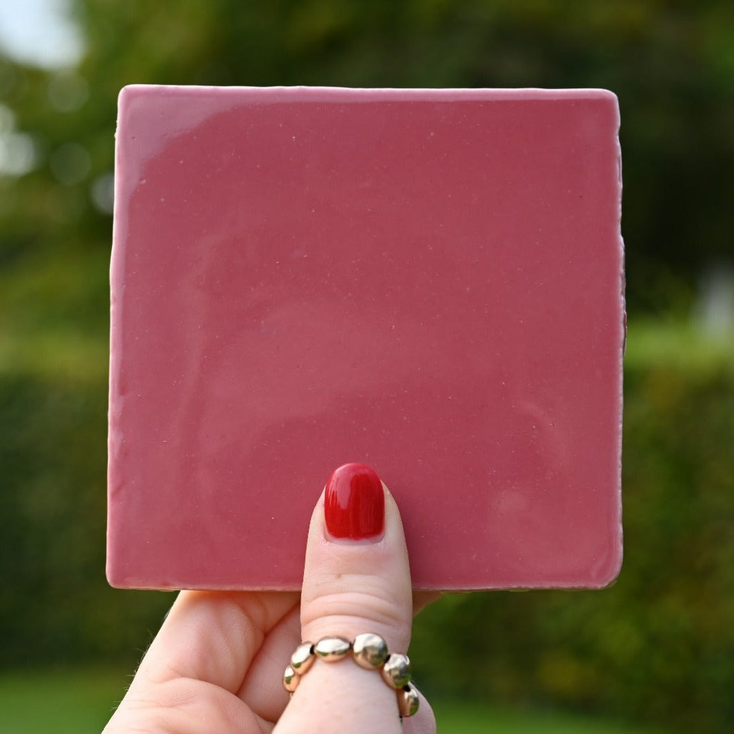 Mooie puur roze gekleurde tegel in de hand in de lucht. Voor jou personaliseren wij deze met liefde