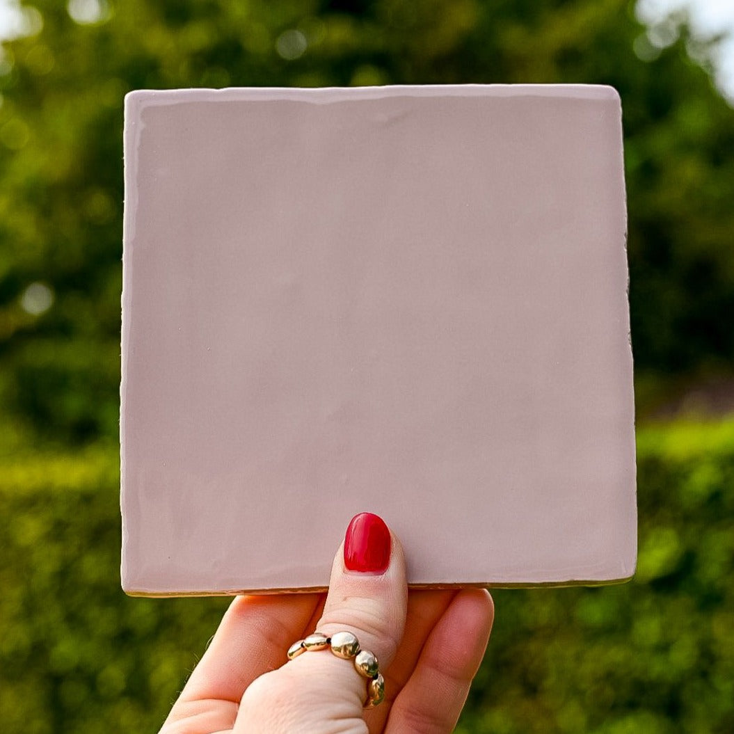 Mooie licht roze gekleurde tegel in de hand in de lucht. Voor jou personaliseren wij deze met liefde